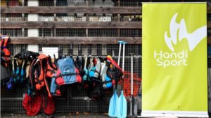 Gilets et pagaies suspendus a coté du kakémono FFH